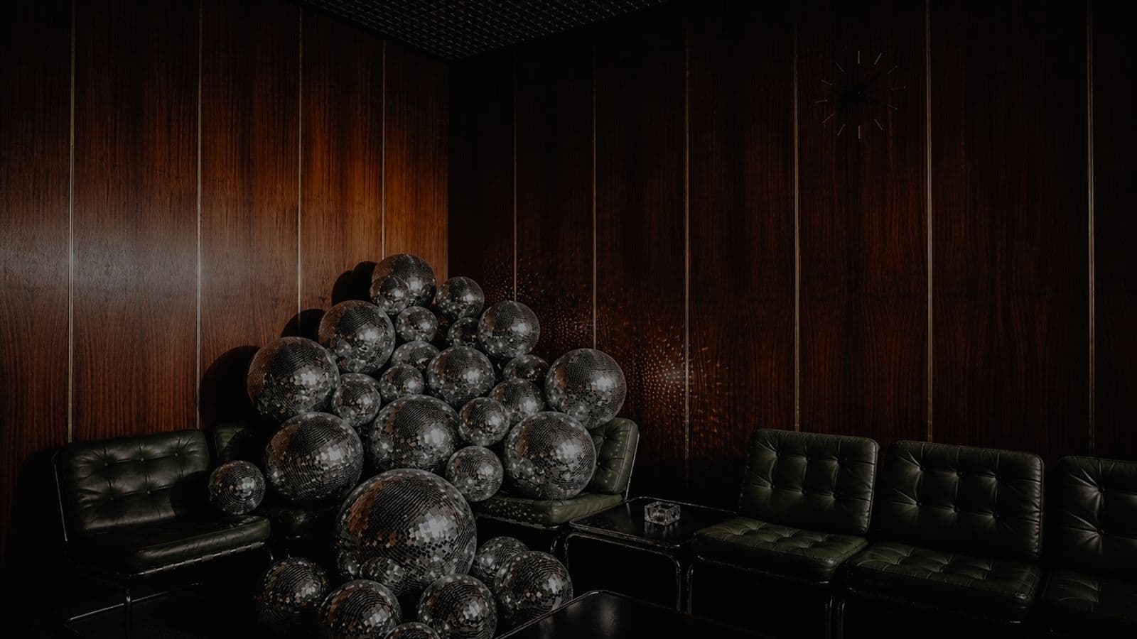 A pile of disco balls in a dark wood-panelled lounge